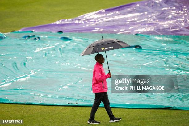 Match official inspects the pitch as rain has delayed start of play ahead of the first T20 cricket match between South Africa and India at Kingsmead...