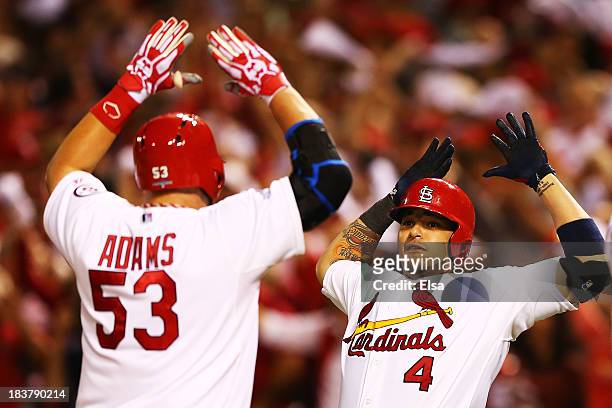 Yadier Molina congratulates Matt Adams of the St. Louis Cardinals on his two-run home run in the eighth inning against the Pittsburgh Pirates during...