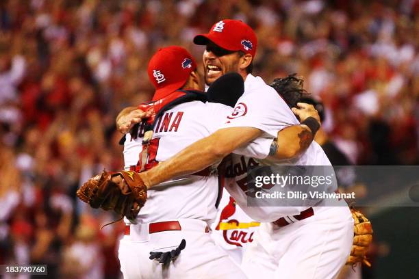 Adam Wainwright celebrates with Yadier Molina of the St. Louis Cardinals after they defeated the Pittsburgh Pirates 6 to 1 in Game Five of the...