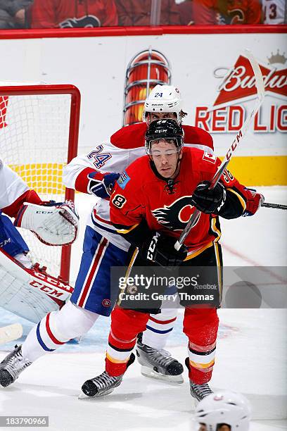 Ben Street of the Calgary Flames is checked by Jarred Tinordi of the Montreal Canadiens at Scotiabank Saddledome on October 9, 2013 in Calgary,...