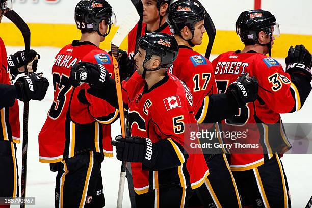Mark Giordano and teammates of the celebrate a 3-2 win over the Montreal Canadiens at Scotiabank Saddledome on October 9, 2013 in Calgary, Alberta,...