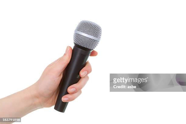 mano sostiene un micrófono - microfoon fotografías e imágenes de stock