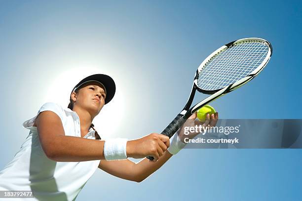 woman holding a tennis racquet ready to serve - tennis quick stock pictures, royalty-free photos & images