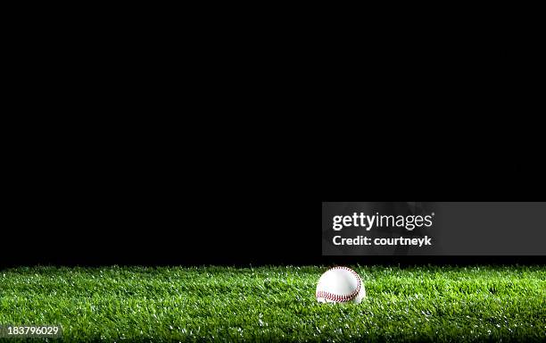 baseball in the grass at night - baseball grass stock pictures, royalty-free photos & images