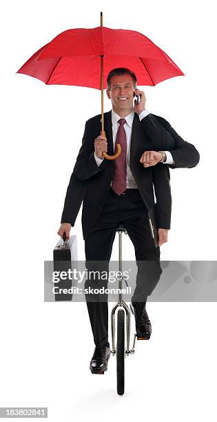 business man multitasking on a unicycle - suit unicycle stock pictures, royalty-free photos & images