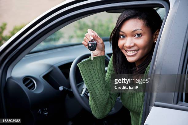 young driver holding up car key - girls driving a car stock pictures, royalty-free photos & images