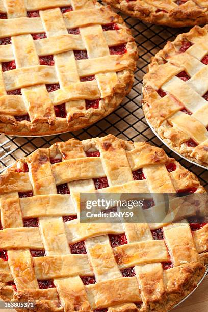 three lattice topped cherry pies on a pie rack - cherry pie stockfoto's en -beelden