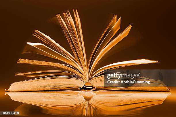 book fanned open on desk with motion blur between pages - fanned book pages stock pictures, royalty-free photos & images