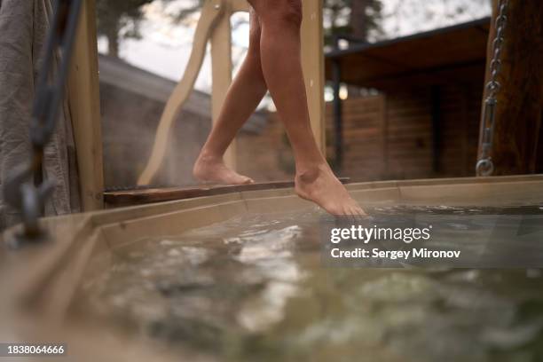 anonymous woman entering into outdoor hot tub - dip toe stock pictures, royalty-free photos & images