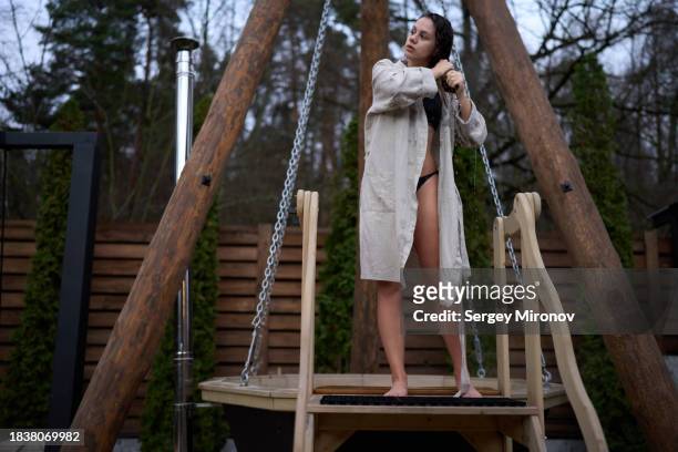 woman leaving open air bath in backyard - woman bath tub wet hair stock pictures, royalty-free photos & images