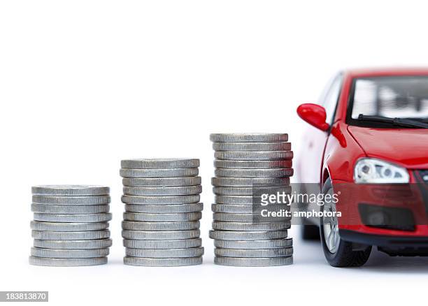 stacks of giant silver coins next to a new red car - land vehicle stock pictures, royalty-free photos & images