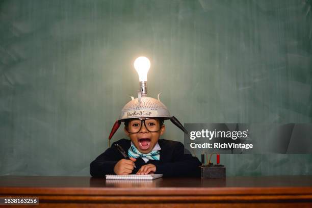 young nerd boy with a light bulb thinking cap - it nerd stock pictures, royalty-free photos & images