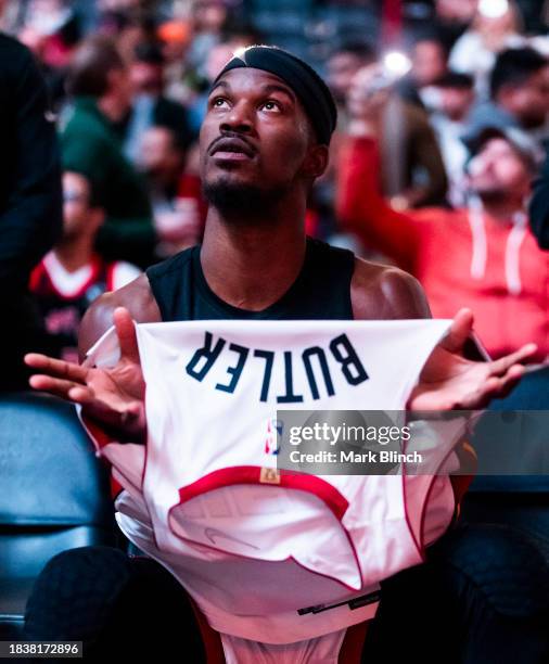 Jimmy Butler of the Miami Heat puts on his jersey ahead of playing the Toronto Raptors before their basketball game at the Scotiabank Arena on...