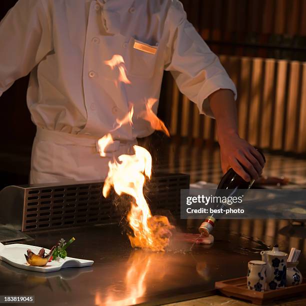 chef cooking food on an iron griddle, teppanyaki-style - teppanyaki stock pictures, royalty-free photos & images