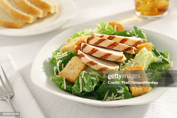 a close-up of a grilled chicken caesar salad for lunch - caesar salad stock pictures, royalty-free photos & images