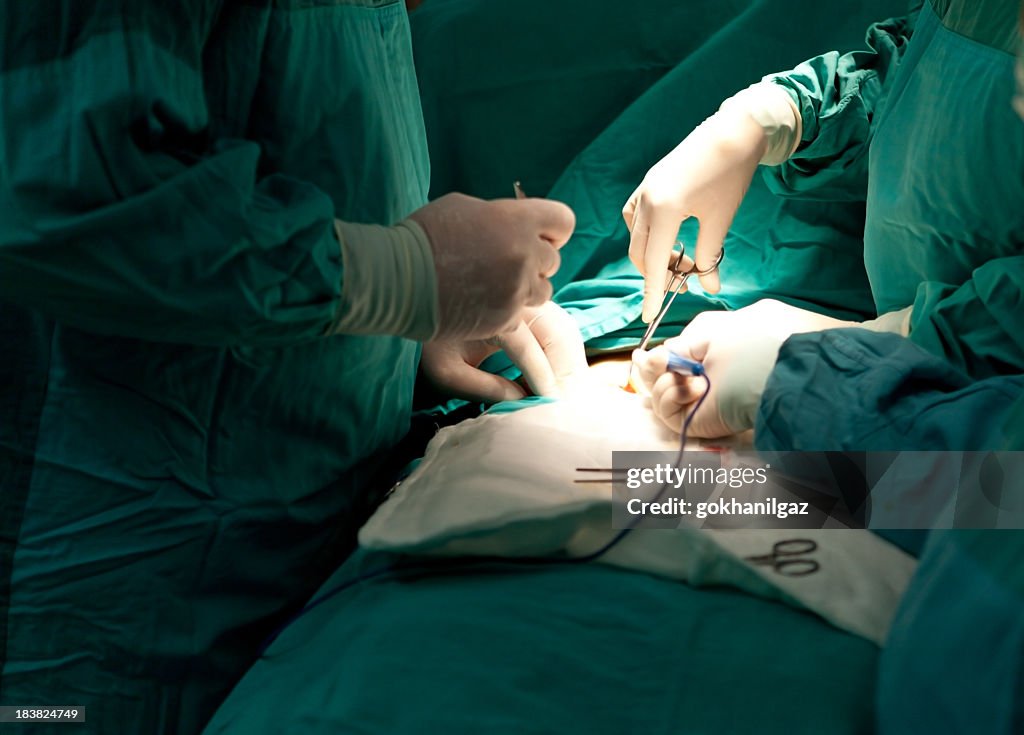 Several doctors performing ear surgery