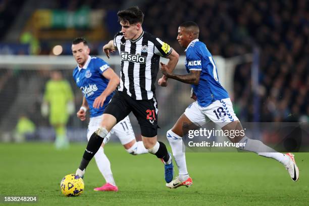 Tino Livramento of Newcastle United runs with the ball whilst under pressure from Ashley Young of Everton during the Premier League match between...