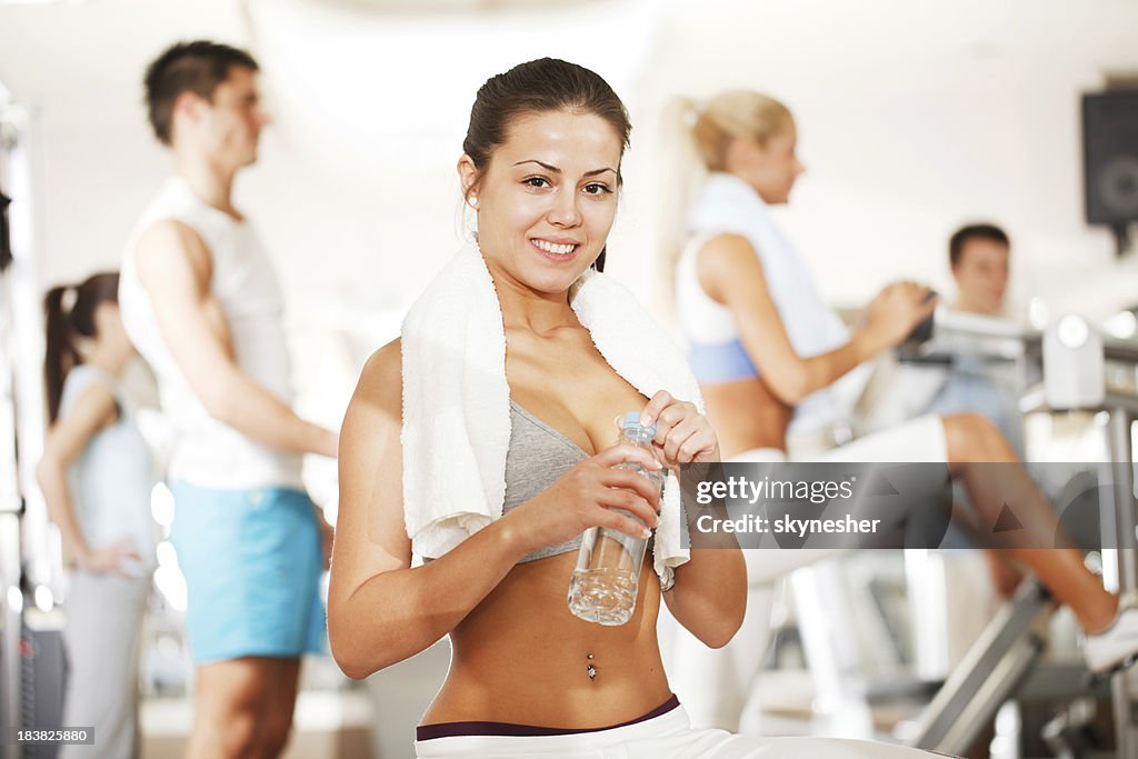 Sporty girl drink water in a fitness center.
