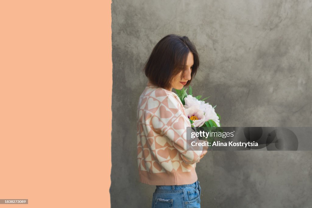 Woman with bouquet of peonies and peach color place for text