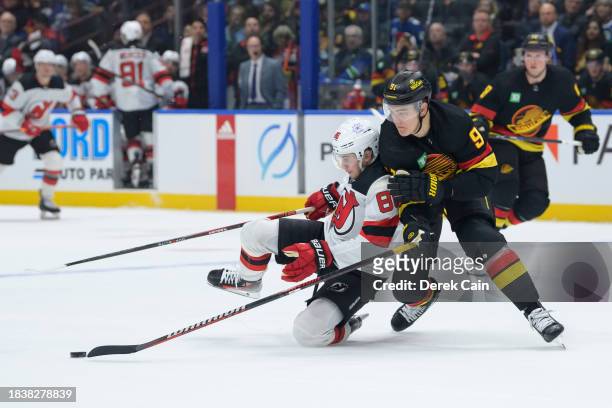 Nikita Zadorov of the Vancouver Canucks defends against Jack Hughes of the New Jersey Devils during the third period of their NHL game at Rogers...