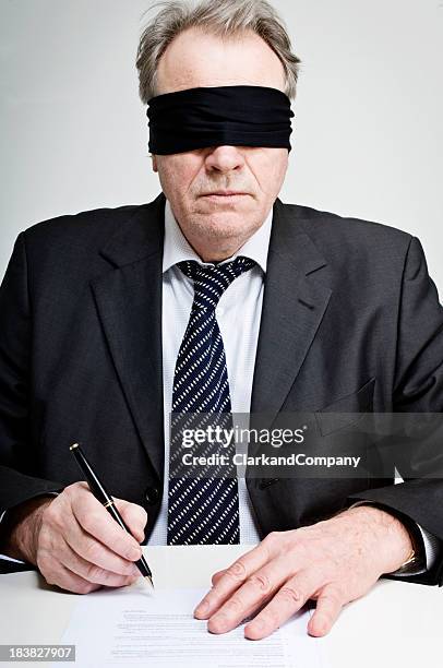 gagged and blindfolded businessman signing a contract - blindfold stock pictures, royalty-free photos & images
