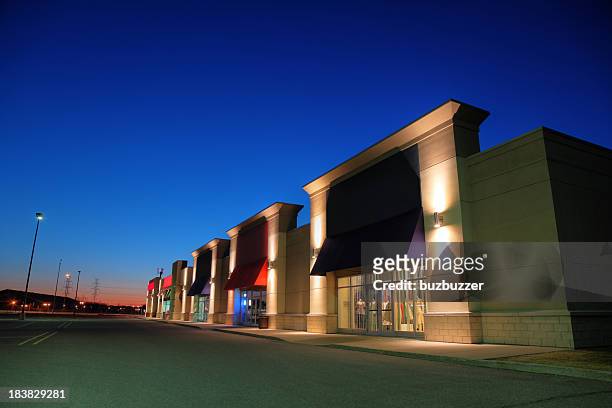 retail store building exteriors at night - market retail space stockfoto's en -beelden