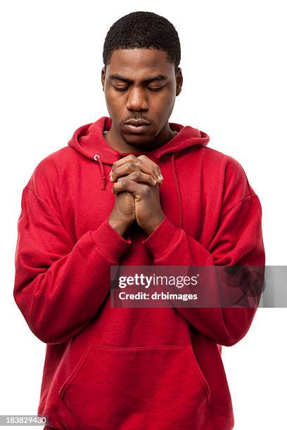 young man praying with hands clasped - black people praying stock pictures, royalty-free photos & images