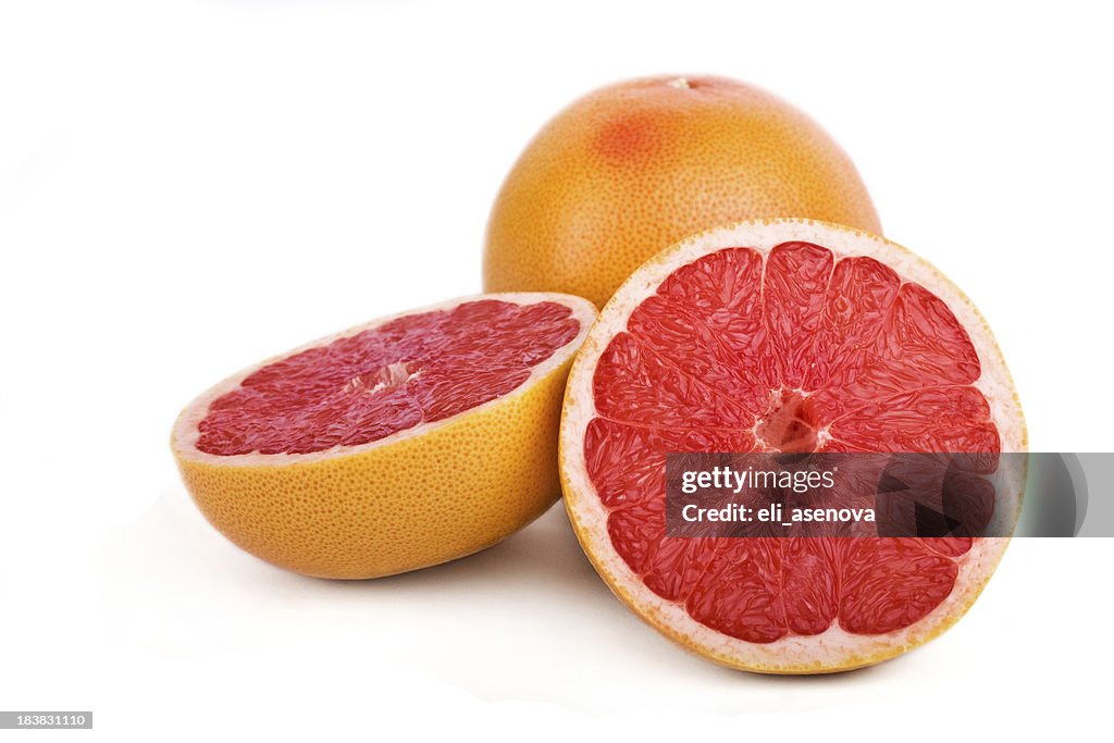 Close-up of one sliced and one full grapefruit