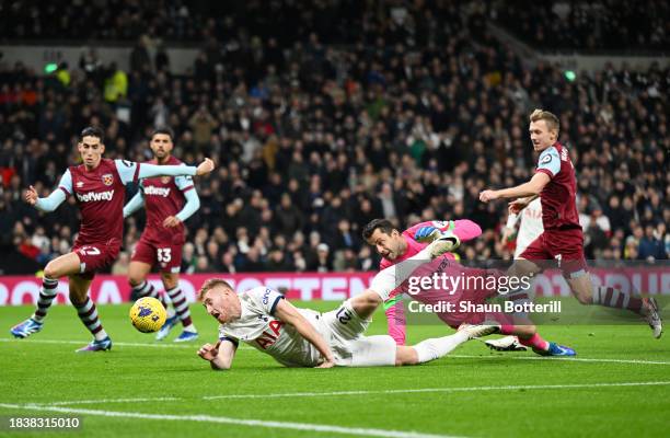 Dejan Kulusevski of Tottenham Hotspur is challenged by Lukasz Fabianski of West Ham United in the box during the Premier League match between...