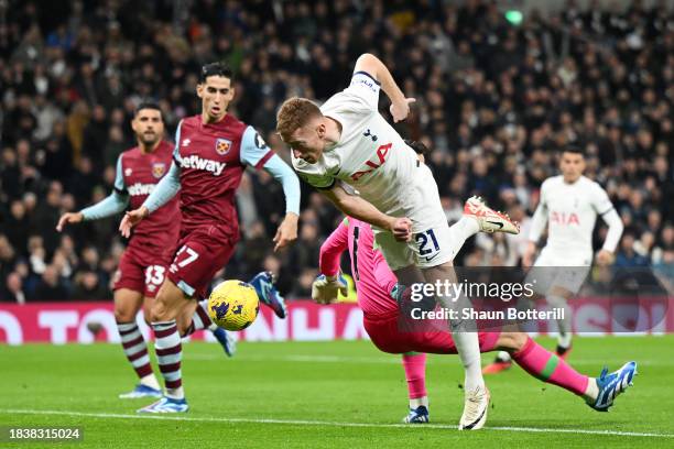 Dejan Kulusevski of Tottenham Hotspur is challenged by Lukasz Fabianski of West Ham United in the box during the Premier League match between...