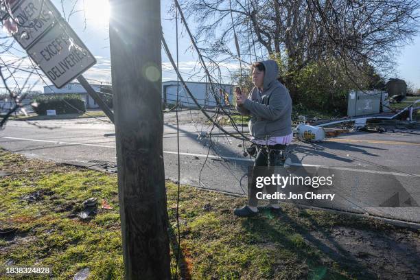 Tiffany Ivy walks through her neighborhood in the aftermath of a tornado on December 10, 2023 in Madison, Tennessee. Multiple long-track tornadoes...