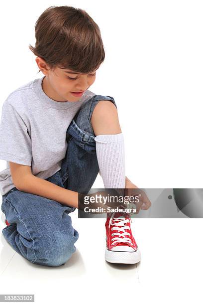 kid binden seine schuhe - boy tying shoes stock-fotos und bilder