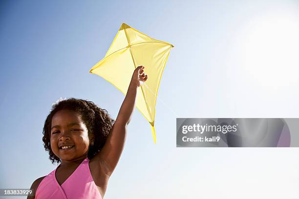 happy girl flying a kite - vlieger stockfoto's en -beelden