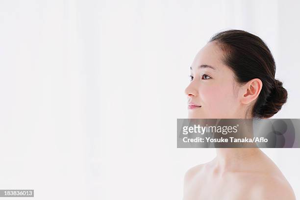 young woman with no make-up looking away - halbbekleidet stock-fotos und bilder