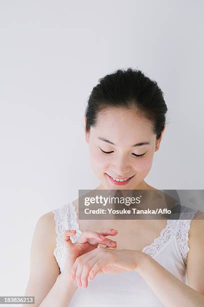 young woman putting foundation cream - dorso mano fotografías e imágenes de stock