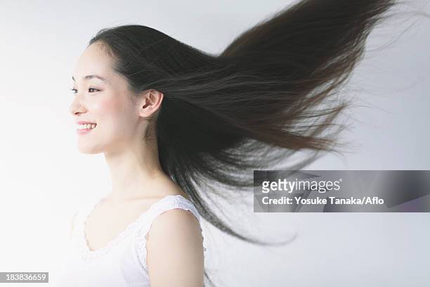 young woman with fluttering hair smiling - cheveux secs photos et images de collection