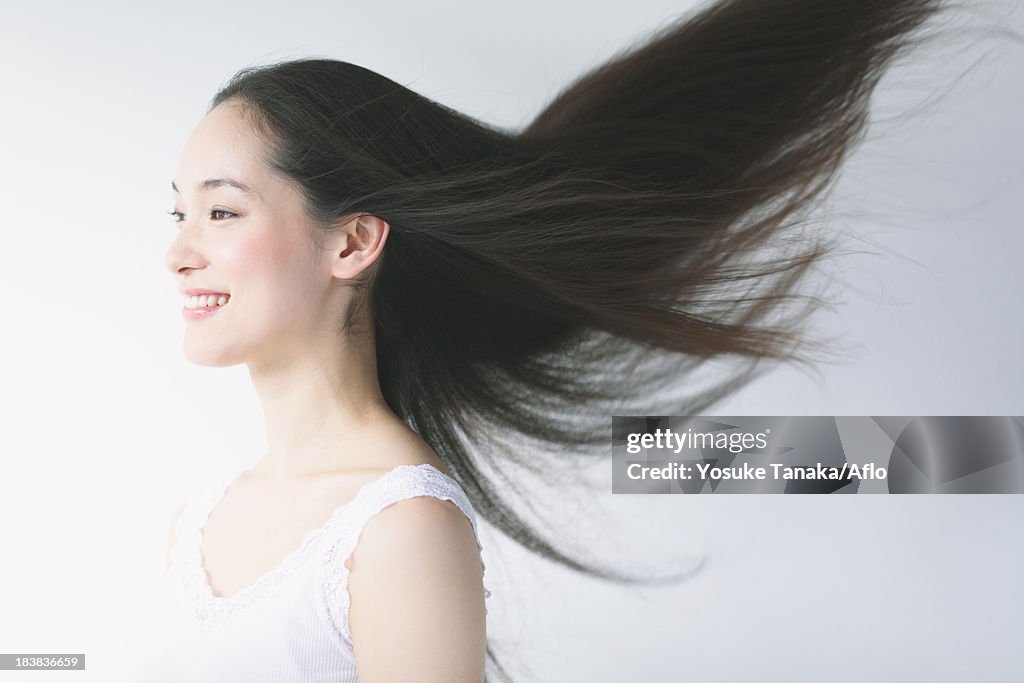 Young woman with fluttering hair smiling