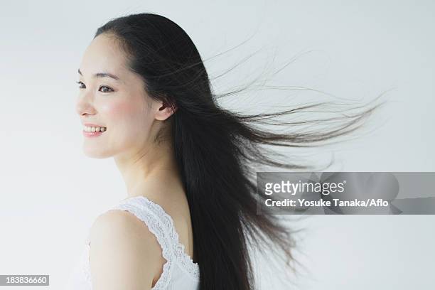 young woman with fluttering hair smiling - cheveux secs photos et images de collection