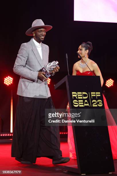 Baloji speaks on stage after receiving the Best Cinematic Contribution Award for 'OMEN' from jury member Freida Pinto during the Closing Ceremony at...