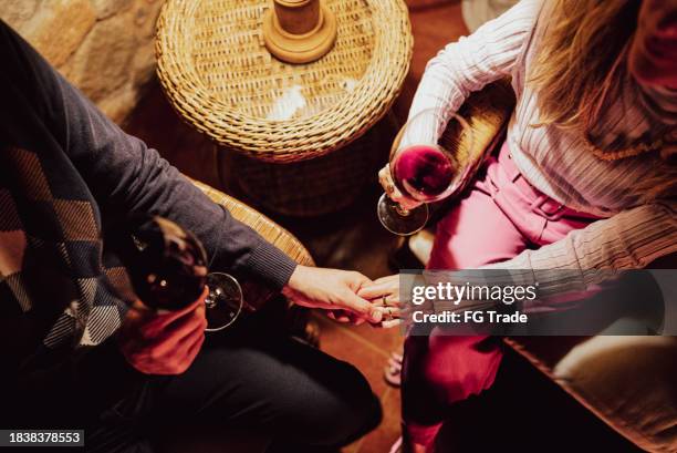 primo piano di coppia romantica che beve vino e si tiene per mano a casa - valentines day dinner foto e immagini stock