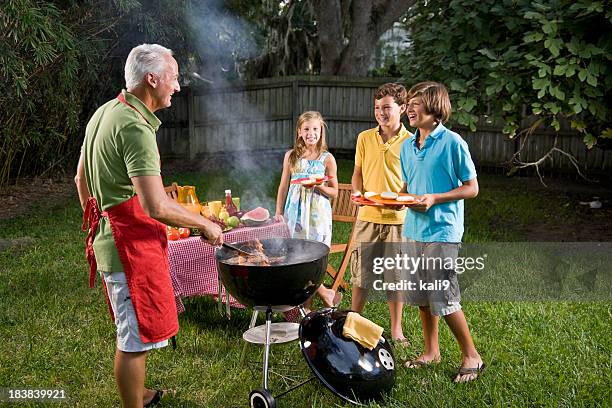 barbecue en famille dans le jardin des hamburgers sur le barbecue - burger portrait photos et images de collection