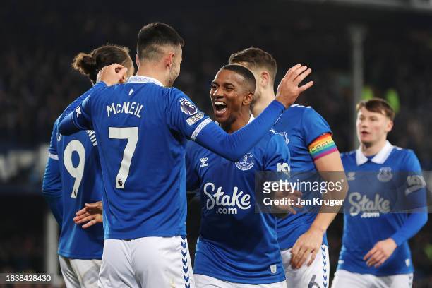 Dwight McNeil of Everton celebrates with teammate Ashley Young after scoring his team's first goal during the Premier League match between Everton FC...