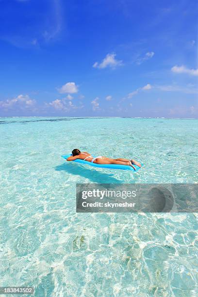 relaxing woman on inflatable mattress. - standing-water stock pictures, royalty-free photos & images