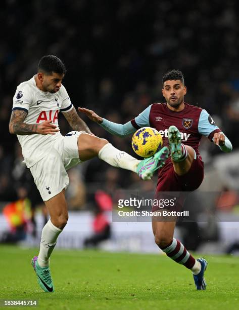 Cristian Romero of Tottenham Hotspur battles for possession with Emerson Palmieri of West Ham United during the Premier League match between...