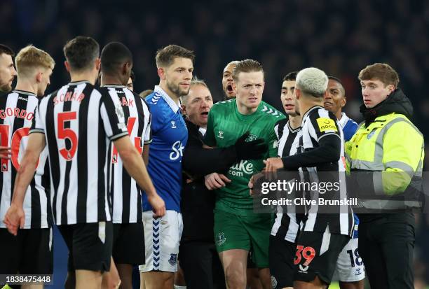 Jordan Pickford of Everton and Bruno Guimaraes of Newcastle United clash following the Premier League match between Everton FC and Newcastle United...