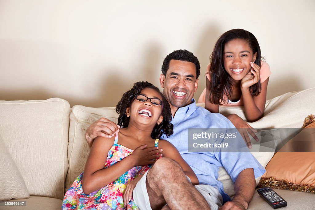 Father and children on couch with TV remote