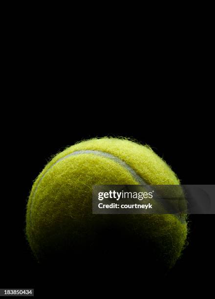 palla da tennis su sfondo nero - palla sportiva foto e immagini stock
