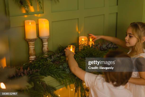 kinder schmücken das haus für weihnachten. elektrische kerze. - adventskranz stock-fotos und bilder