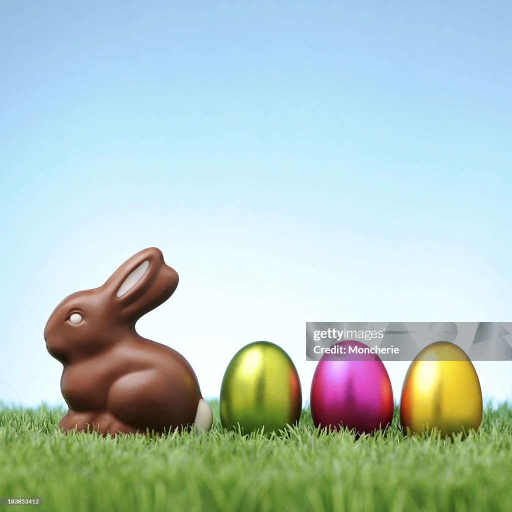 Chocolate rabbit with colorful easter eggs