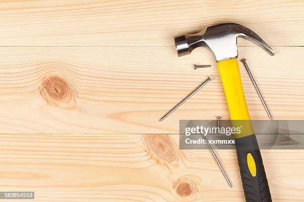 hammer and nails on a wooden table - spijker stockfoto's en -beelden
